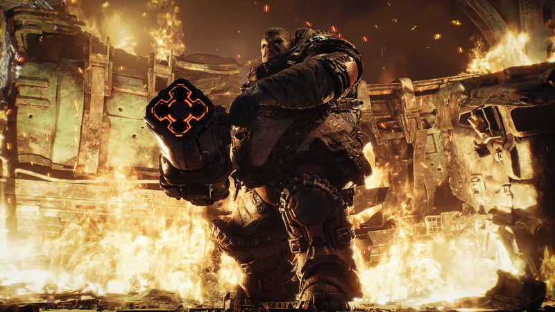 A heavily armored figure carries a large square-barreled weapon through a street engulfed in flames